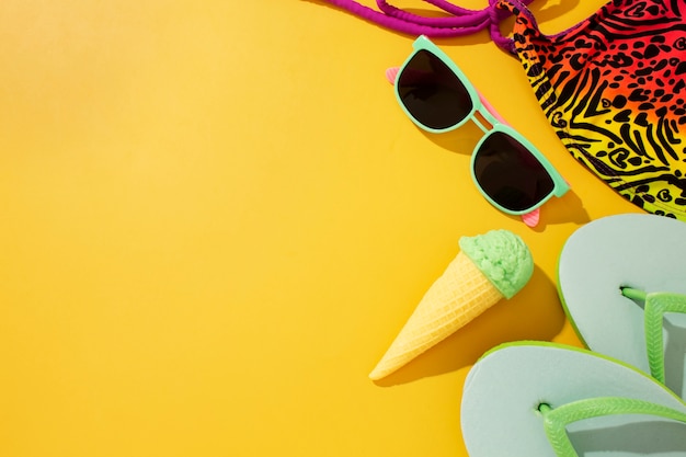 Бесплатное фото Вид на шлепанцы с летними предметами первой необходимости и мороженым