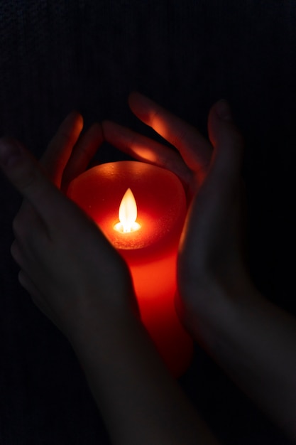 Бесплатное фото Вид на руки, держащие свет свечи