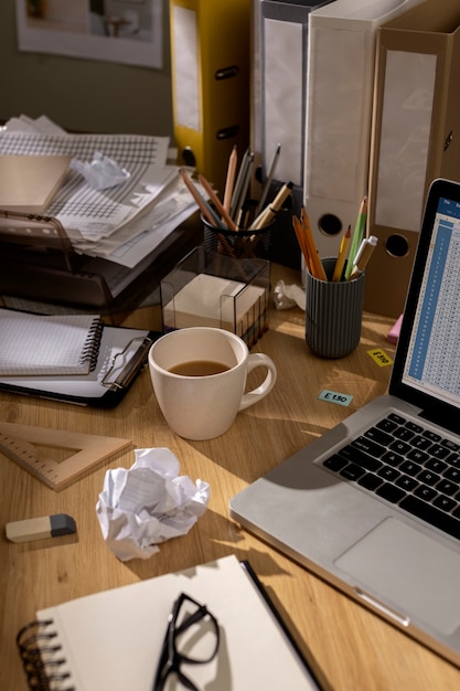 Free photo view of office desk with messy workspace and laptop