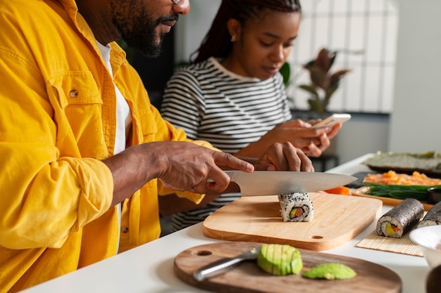 Foto gratuita la vista delle persone che imparano a preparare il tradizionale piatto di sushi