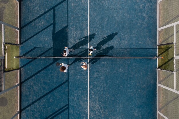 Вид сверху на людей, играющих в паддл-теннис