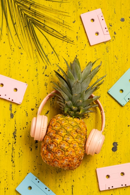 Free photo view of pineapple fruit with cassette tapes and headphones