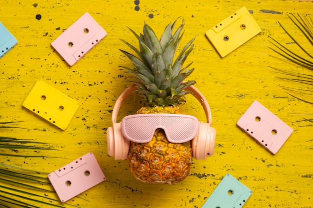 View of pineapple fruit with cool sunglasses and headphones