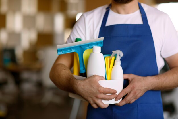 View of professional cleaning service person holding supplies