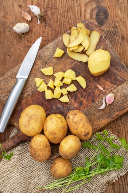 Above view raw potatoes on wooden board