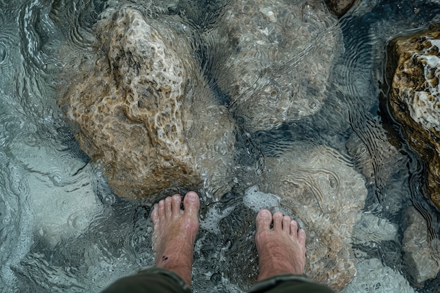 Вид реалистичных ног, касающихся чистой текущей воды
