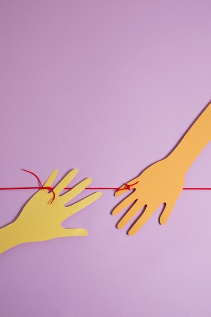 Free photo view of red thread with cardboard hands