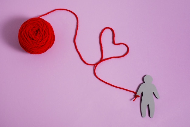 Free photo view of red thread with human figurine