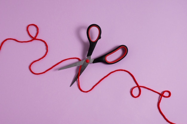 Free photo view of red thread with scissors