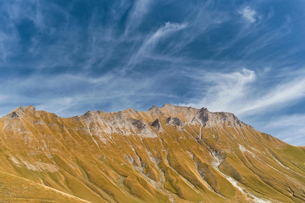 山の岩の多い尾根の秋の眺め空は雲で覆われている山でのジョージア トレッキングへのテキスト旅行のためのスペースを持つバナーまたはポストカードのアイデア