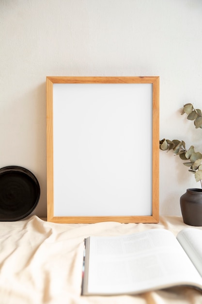 View of room decor made up of frame and plant vase with magazine