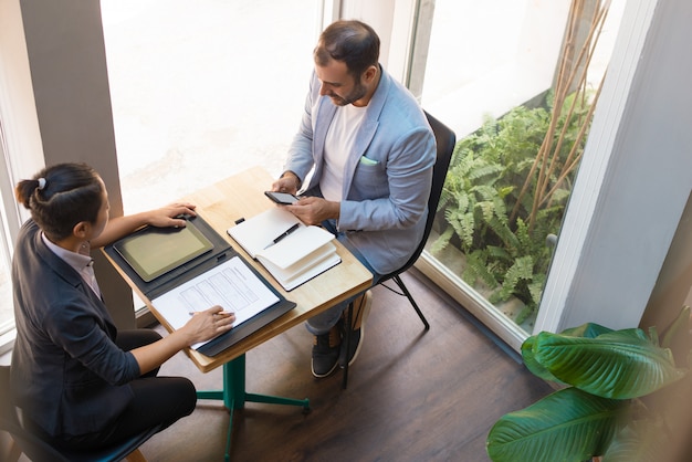 Above view of serious business partners having meeting in cafe