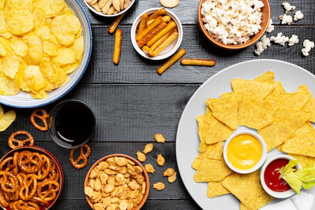 Above view snacks on wooden background