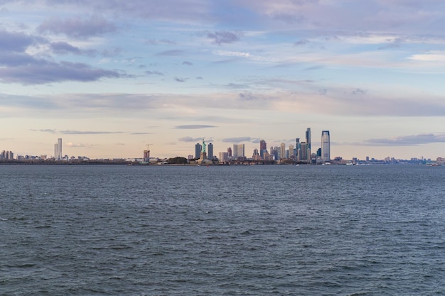 View of the Statue of Liberty from the water at sunset, New York, USA