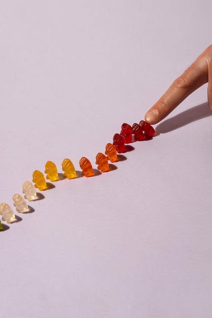 View of sweet gummy bears with finger