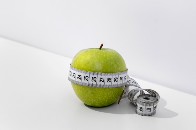 Free photo view of tape measure with apple fruit