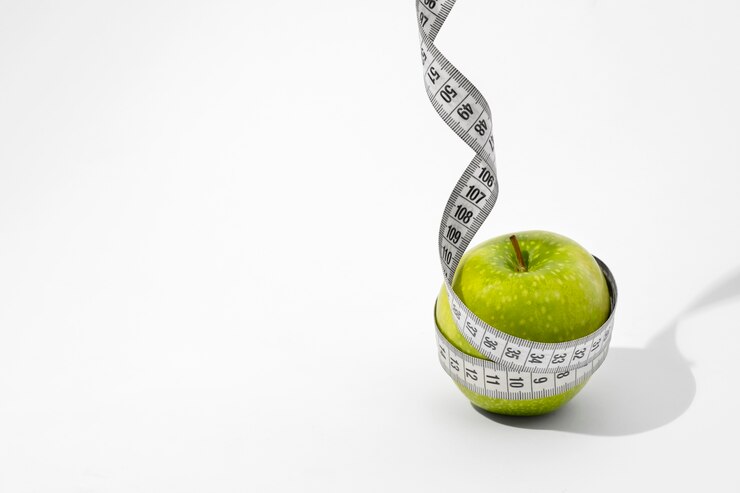 Free Photo view of tape measure with apple fruit
