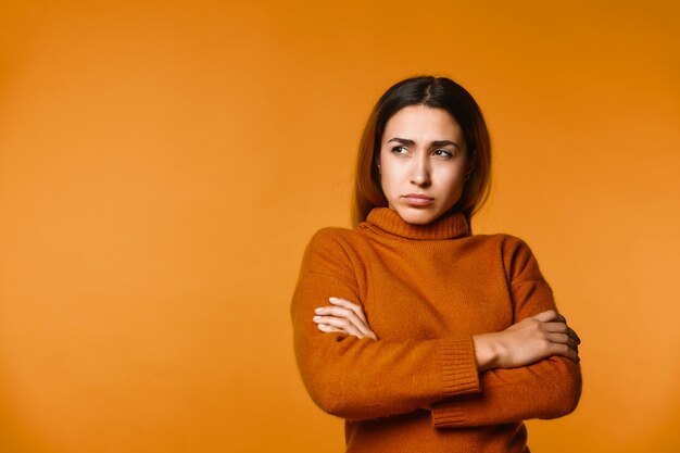 View of thoughtful young caucasian woman dressed in pullove, seriously focused