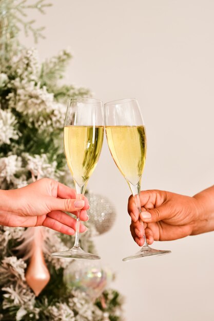 View of a toast with champagne glasses being made by two female hands