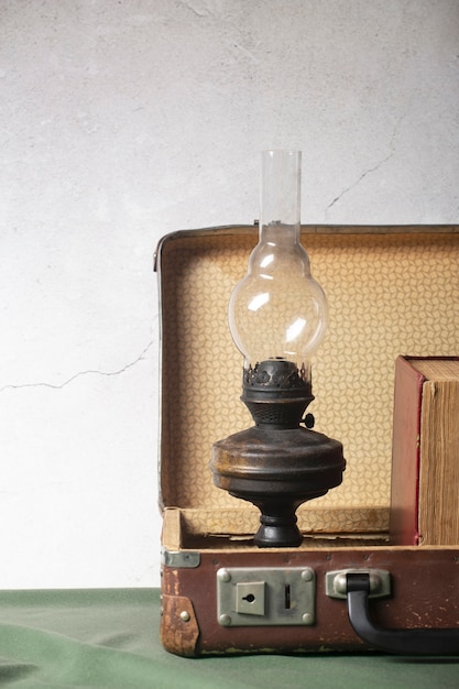 Free photo view of vintage briefcase with books and lamp