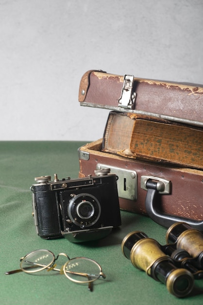 Foto gratuita vista della fotocamera vintage con valigetta e libri