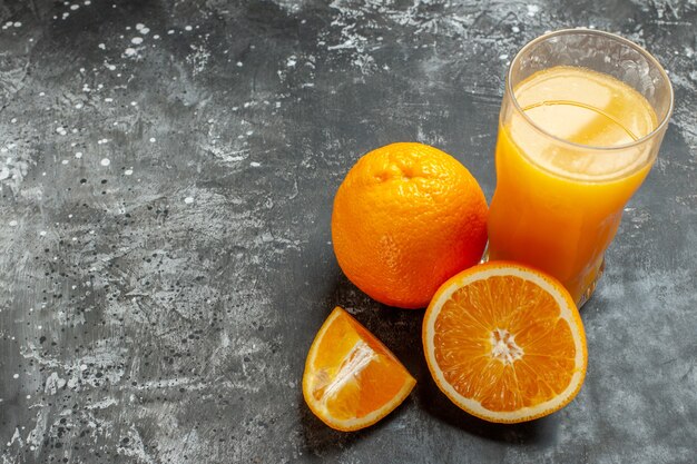 Above view of vitamin source cut and whole fresh oranges and juice on gray background