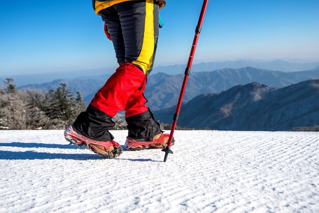 冬のスノーシューと靴のスパイクで雪の上を歩くビュー