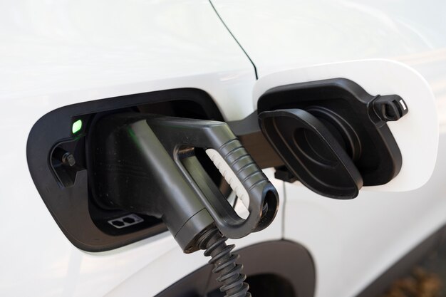 View of white electric car charging at a station