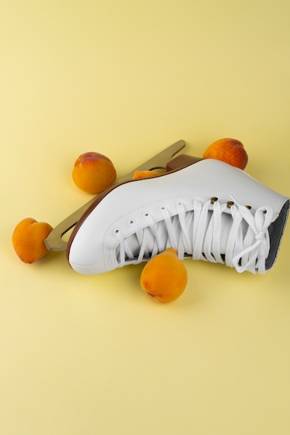 View of white ice skates with peaches