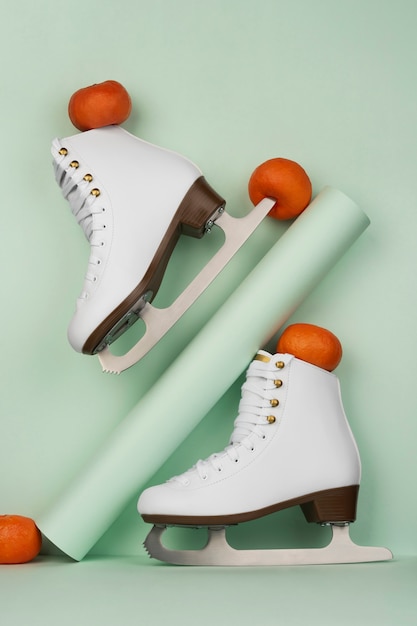 Free photo view of white ice skates with tangerines