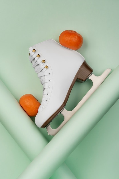 Free photo view of white ice skates with tangerines