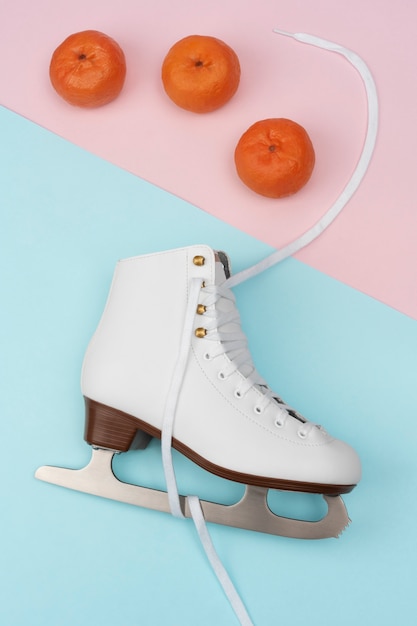 View of white ice skates with tangerines