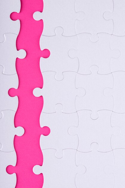 Above view white puzzle pieces and pink background