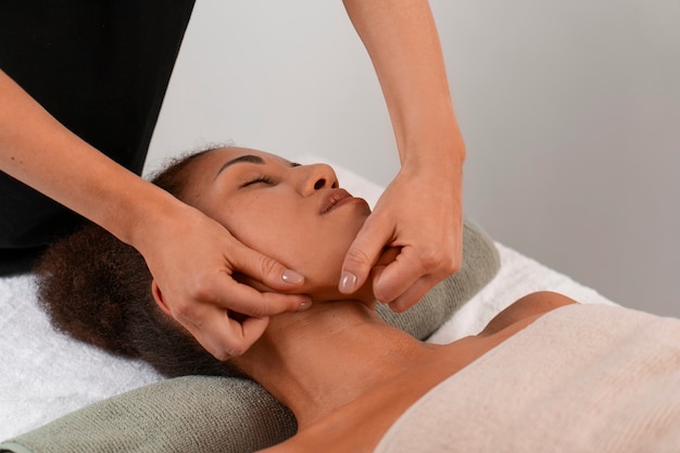 View of woman getting a facial yoga massage to stay young