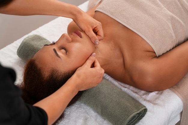 Free photo view of woman getting a facial yoga massage to stay young