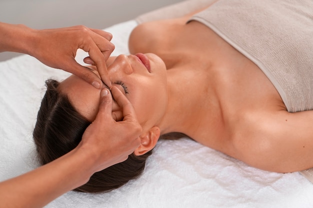 Free photo view of woman getting a facial yoga massage to stay young