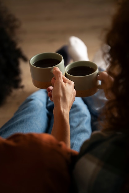 家で温かい飲み物を飲みながらくつろぐ女性の姿