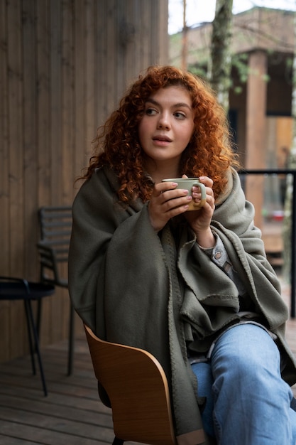 Free photo view of woman relaxing at home with a warm drink