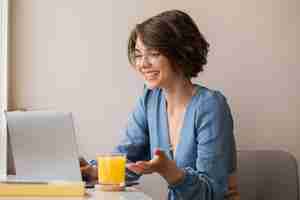 Foto gratuita vista della donna che sorride sul computer portatile a casa