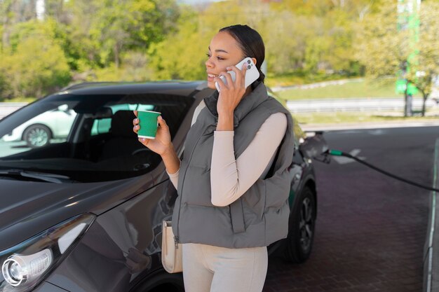 ガソリンスタンドで車を持つ女性の眺め