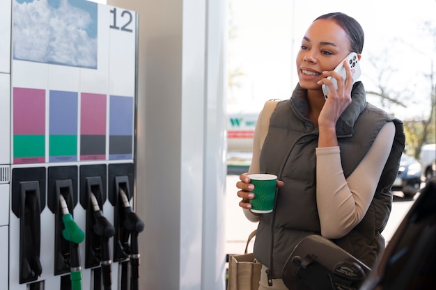 Foto gratuita punto di vista della donna con l'automobile alla stazione di servizio