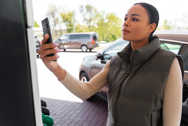 ガソリンスタンドで車を持つ女性の眺め