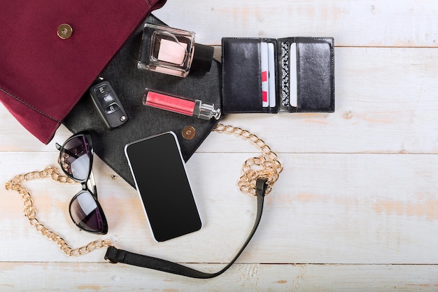 View on women bag stuff on wooden background