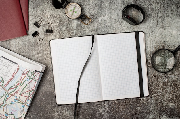 View of world travel map with notebook and magnifying glass