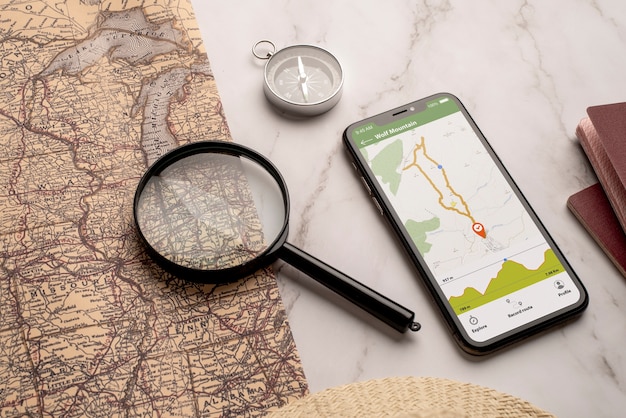 Free photo view of world travel map with smartphone and magnifying glass