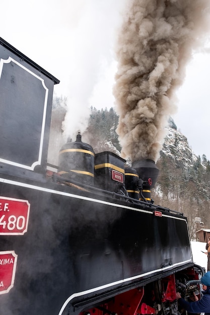 Vista del treno a vapore avvolto mocanita su una stazione ferroviaria in inverno neve romania