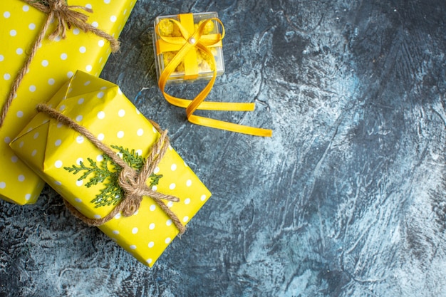 Выше вид рождественского фона с желтыми подарочными коробками на темном фоне