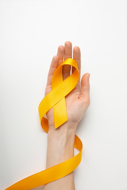 Free photo view of yellow ribbon with human hand