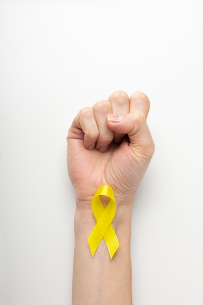 Free photo view of yellow ribbon with human hand