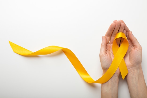 View of yellow ribbon with human hands